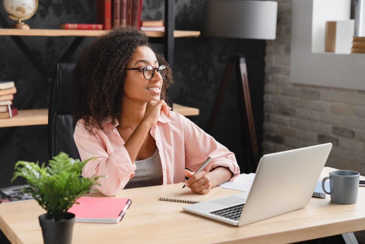 Schoolgirl writing essay, poem, novel with imagination, doing homework assignment using laptop